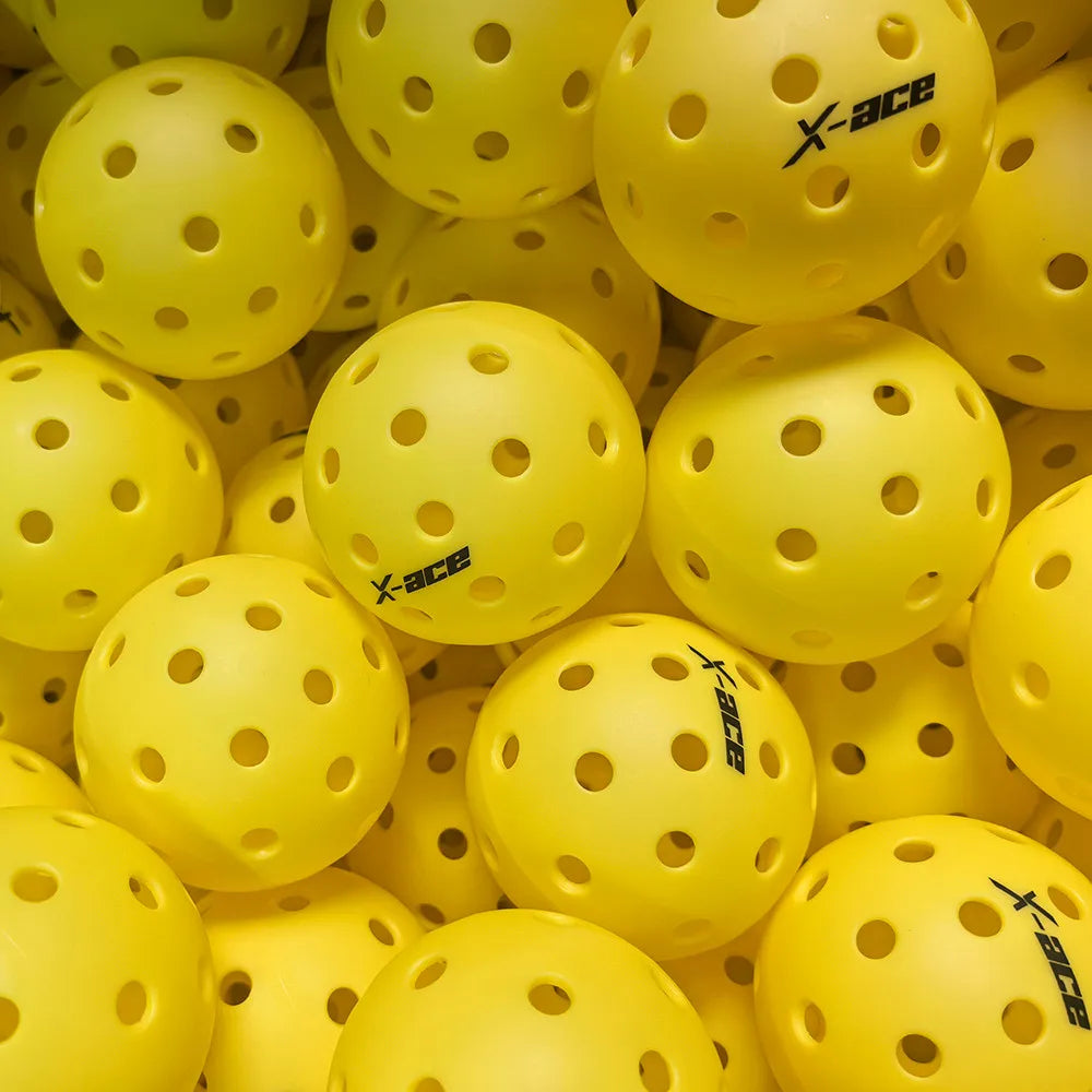 Balles X-ace pour le pickleball en extérieur, jaune vif, photographiées de près dans un bac de balles