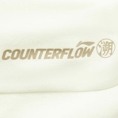 Haut manches longues femme Li-Ning : gros plan sur l'inscription Counterflow beige imprimée sur l'épaule écrue