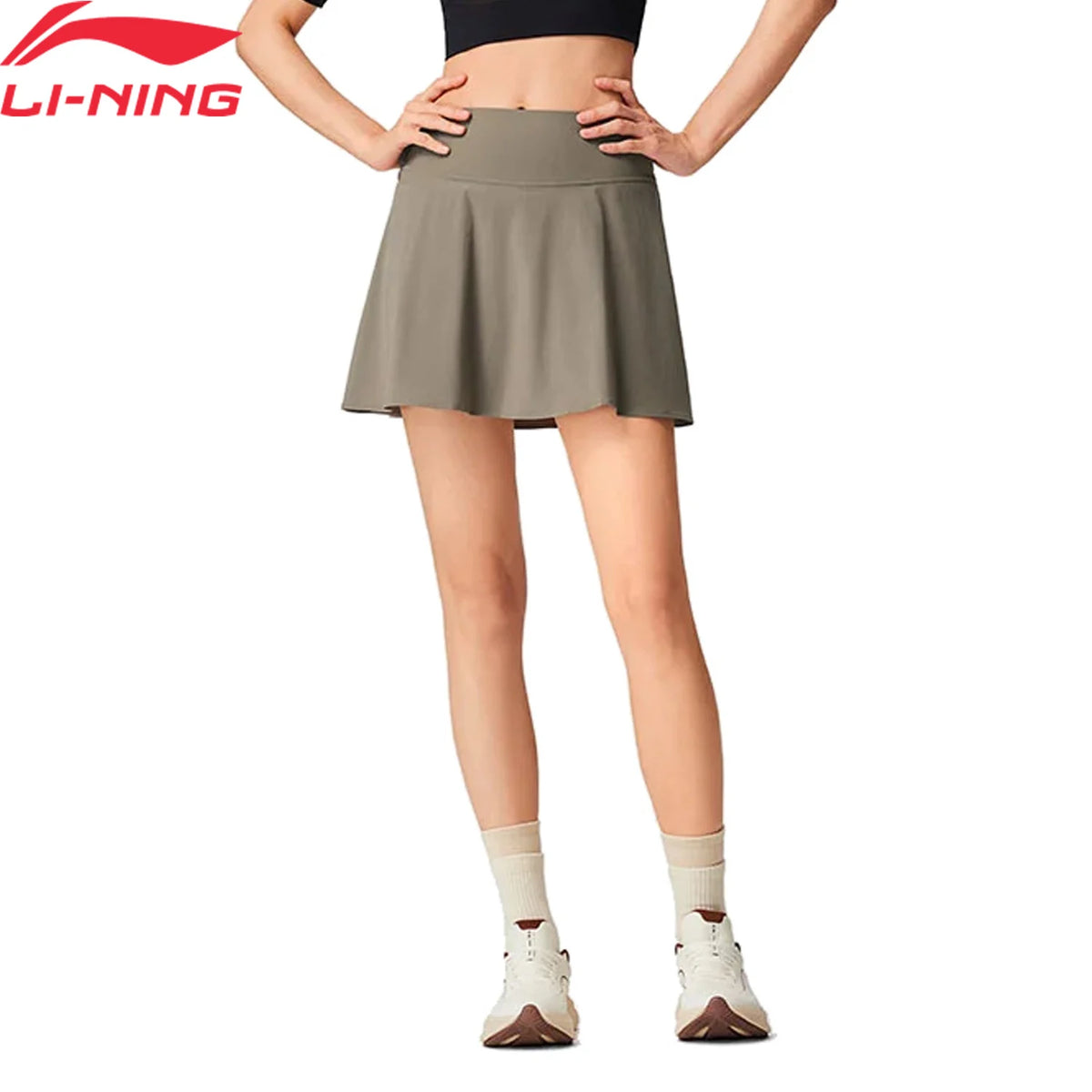 Jupe-short femme Li-Ning LN DRY taupe portée, taille haute et jupe évasée à plis, vue de face sur fond blanc